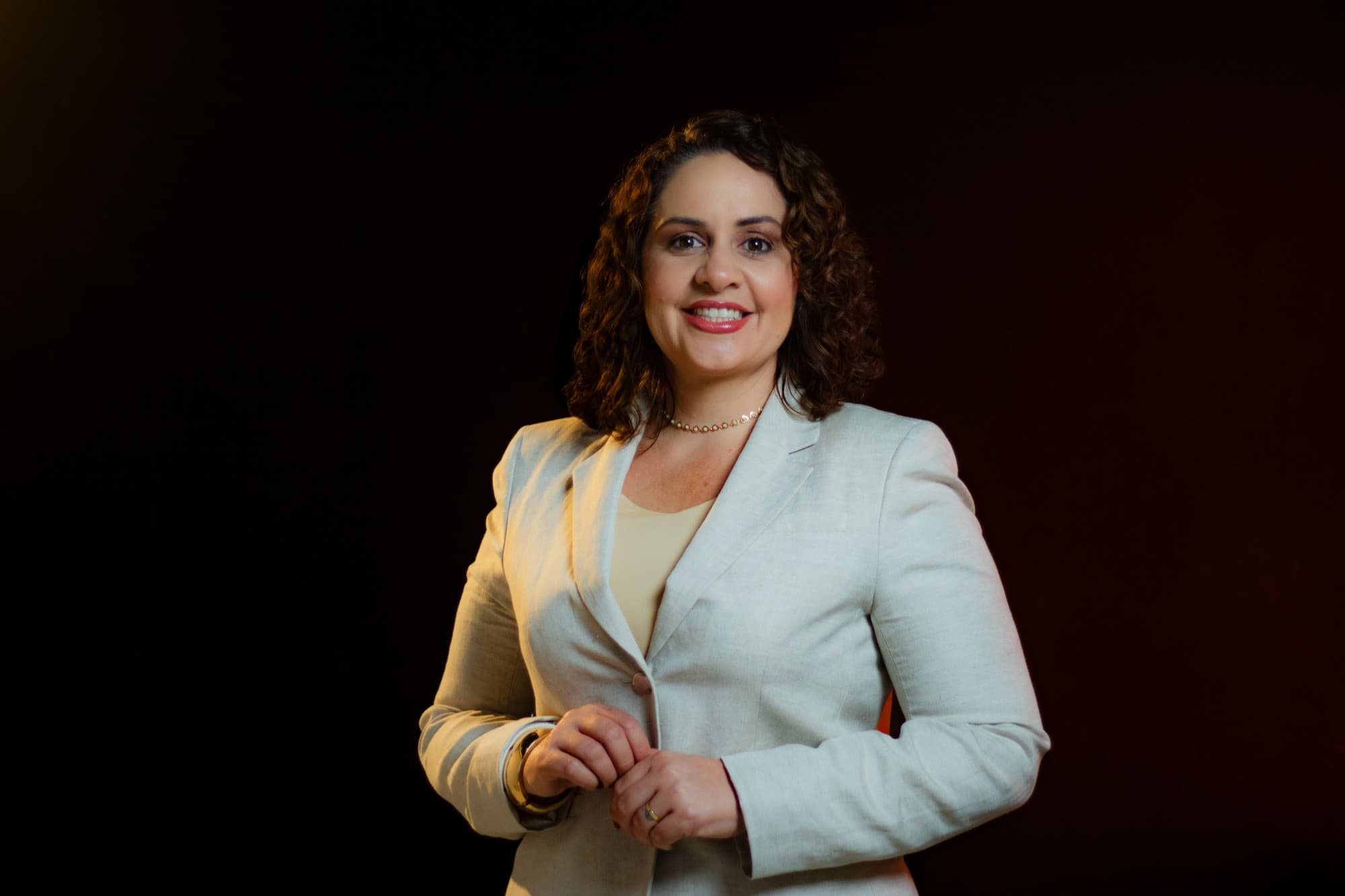 Camila Mota Figueiredo sorrindo, de terno de linho claro